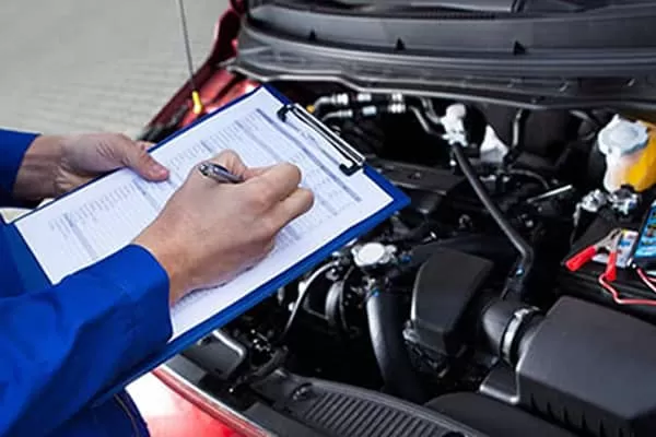 Mecánico completando la planilla de revisión de un auto