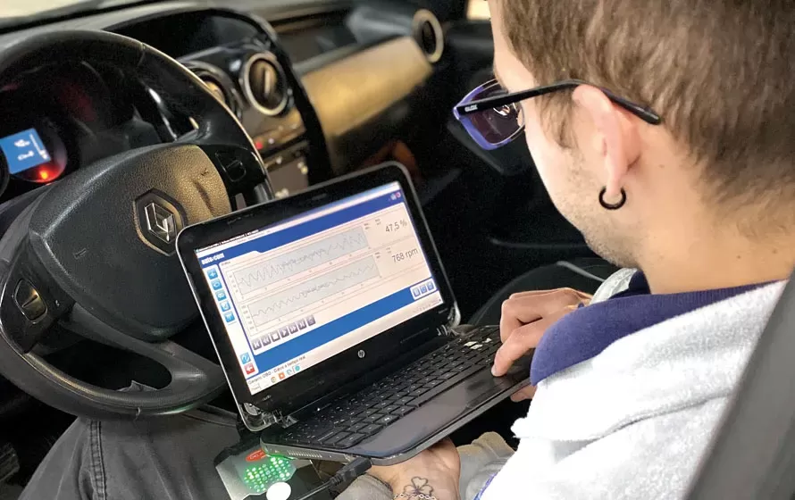 Mecánico de Qualis revisando un auto con el escáner